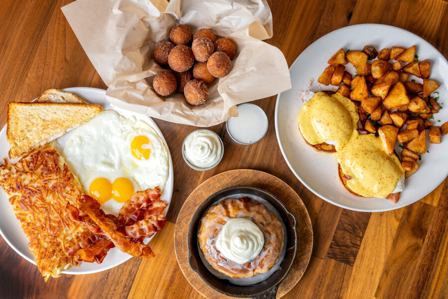 Top view breakfast - donut holes, cinnamon roll, eggs benedict